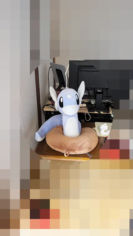キッチンからの視線に応えるように部屋の奥から見守るミニリュウのぬいぐるみ
