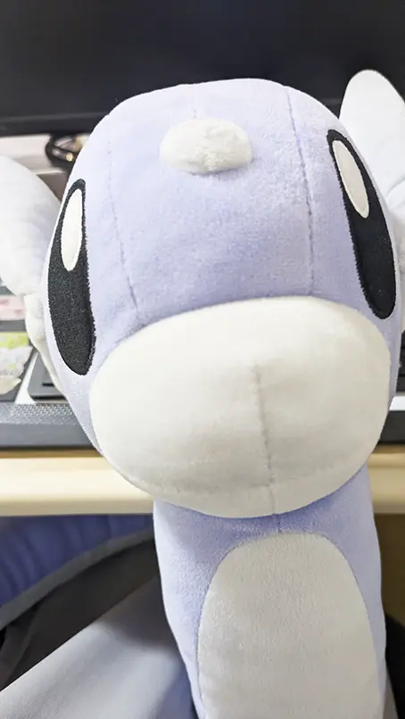 パソコン作業中に膝の上に乗せてじっと見つめてくるミニリュウのぬいぐるみ